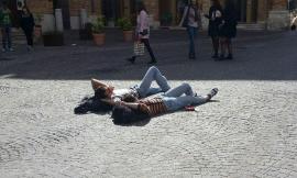 Due ragazzi si godono il primo sole di primavera in piazza a Macerata
