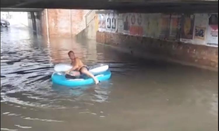 Il maltempo non frena un turista: bagno col canotto nel sottopasso allagato dopo il temporale - VIDEO