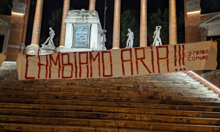 Macerata, compare lo striscione "Polveri sottili e solite facce: Cambiamo Aria"sotto il Monumento ai Caduti
