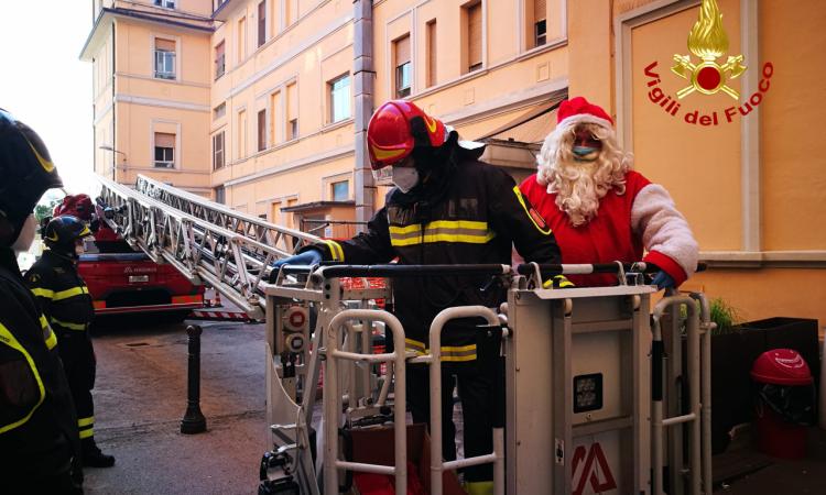 I vigili del fuoco al Salesi: Babbo Natale sale sull'autoscala e bussa alle finestre dei piccoli pazienti (FOTO)