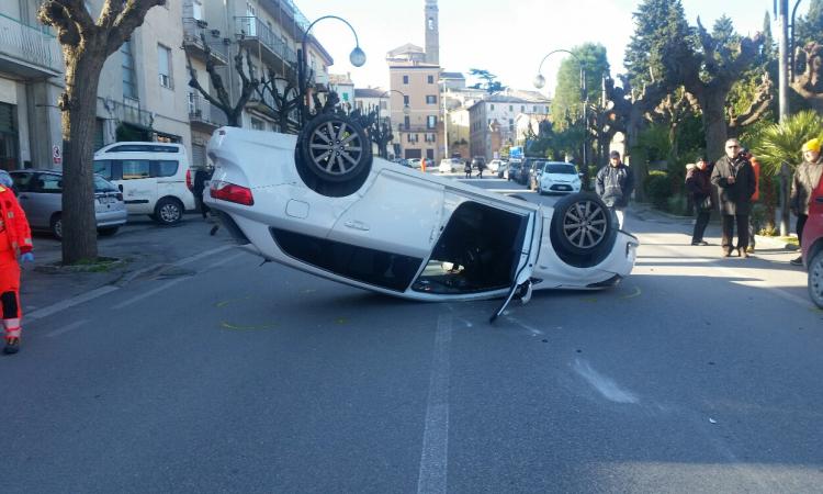 Finisce contro un'auto parcheggiata e si ribalta