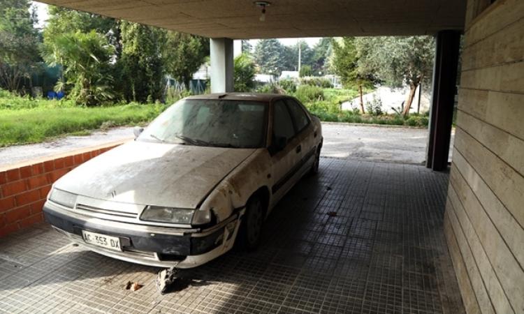 Un auto nel porticato come discarica